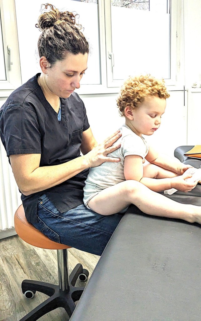 vérification de la mobilité du dos lors d'une consultation d'ostéopathie pour un enfant de 3ans