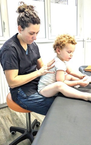 vérification de la mobilité du dos lors d'une consultation d'ostéopathie pour un enfant de 3ans
